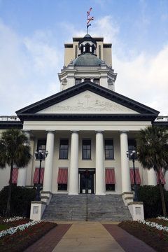 A large white building with columns and a dome on top of it.