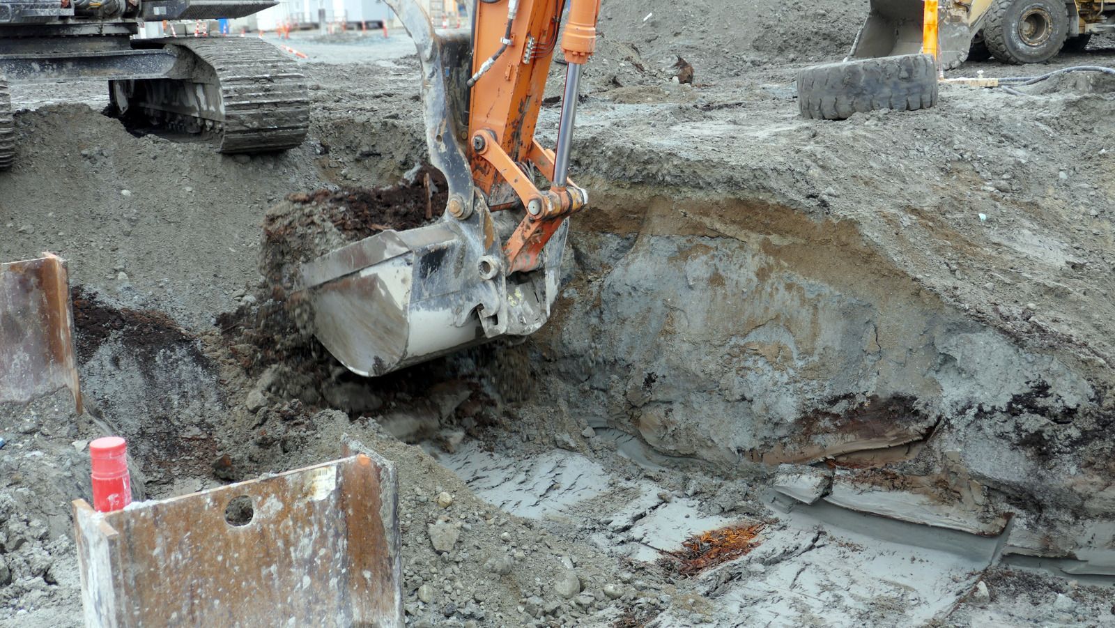 A yellow excavator is digging a hole in the ground.
