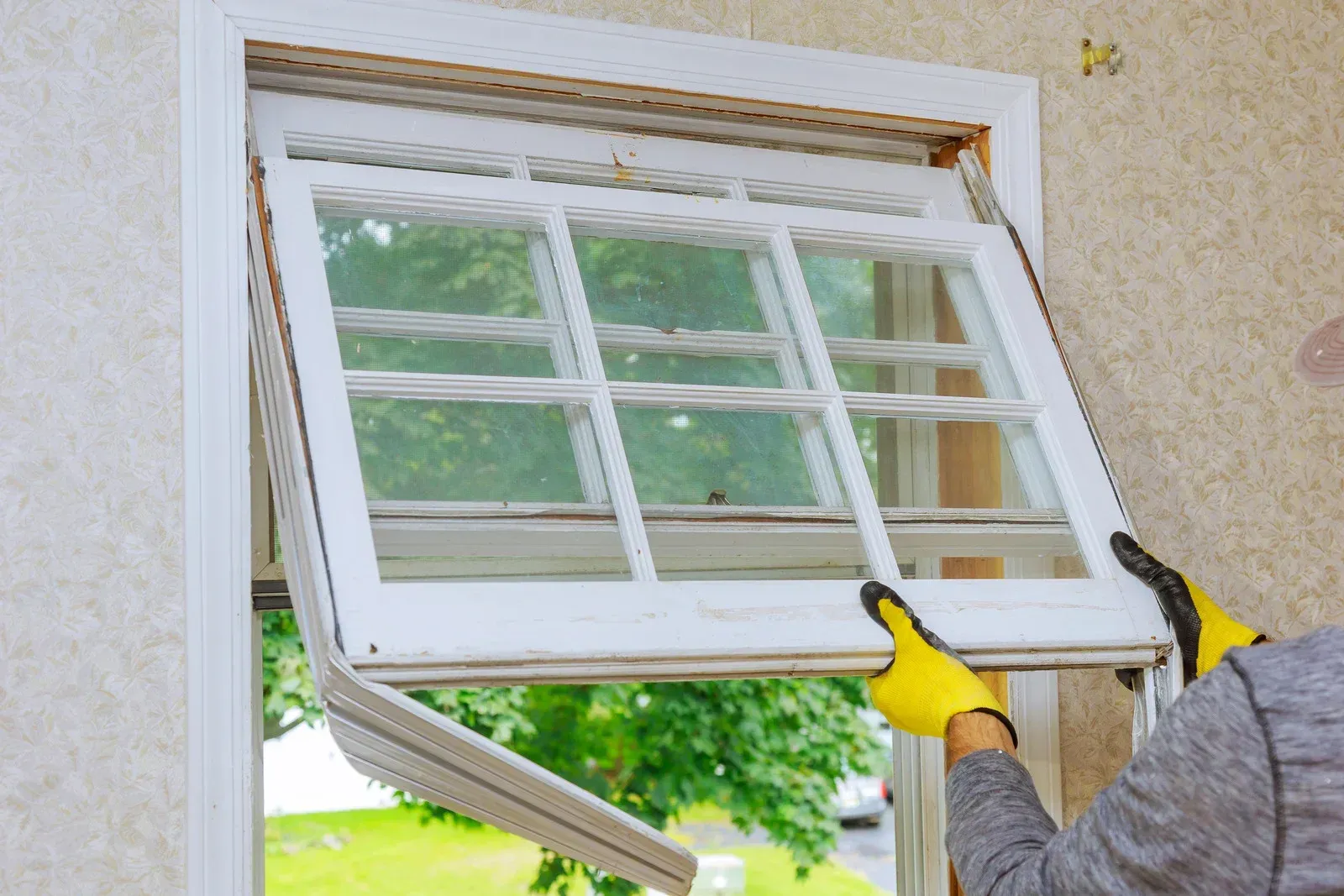 A man is installing a window in a house.