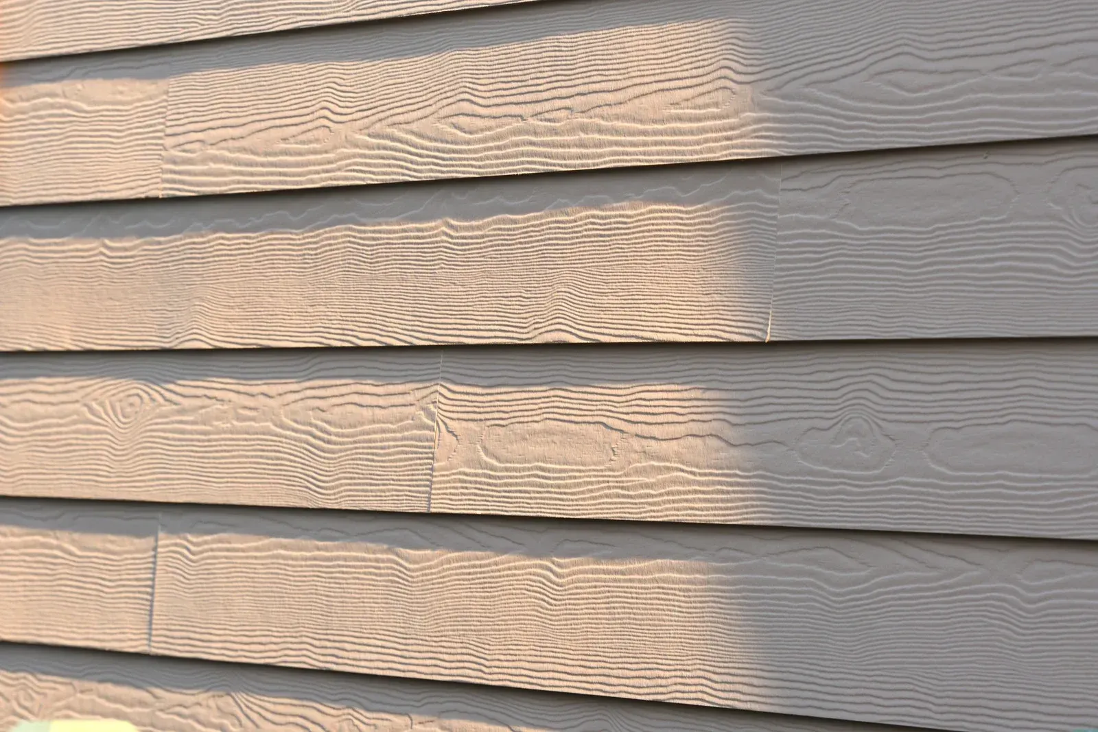 A close up of a siding on a house with a light shining on it.