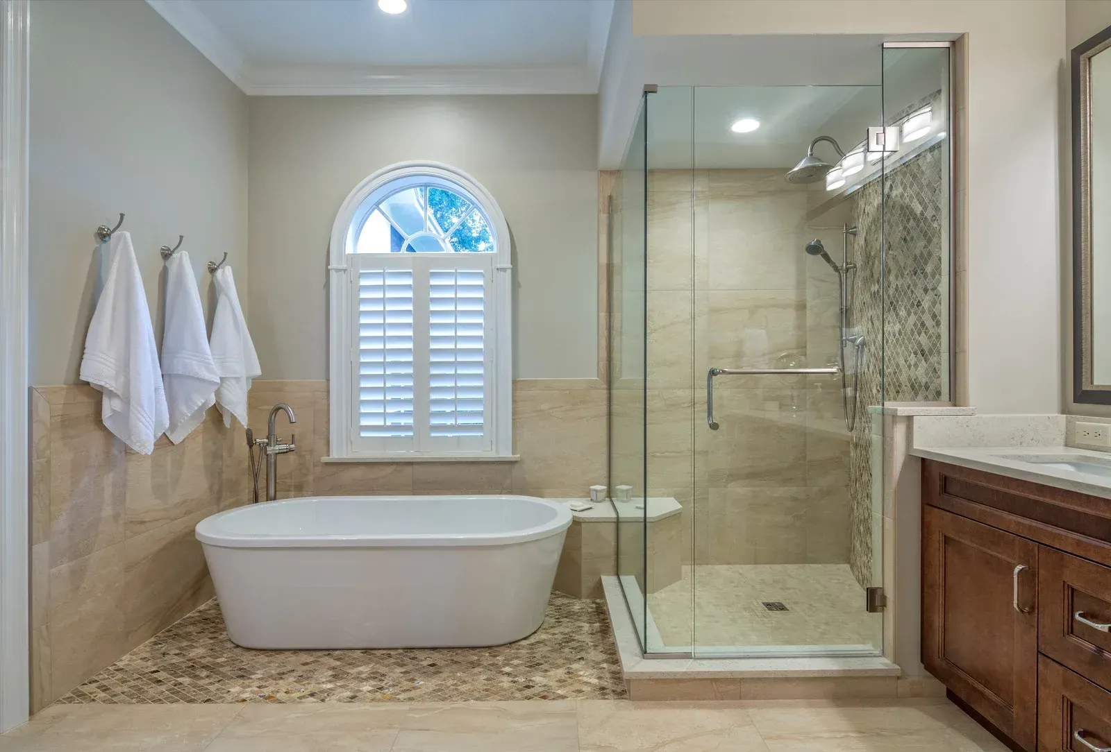 A bathroom with a tub , sink , shower and window.