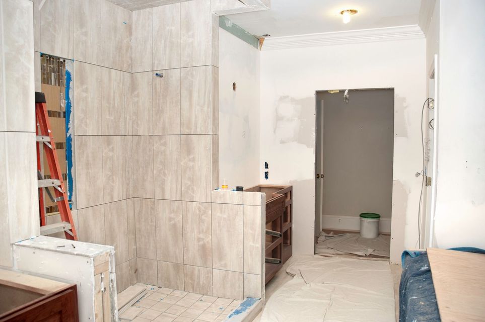A bathroom is being remodeled with tile and a ladder.