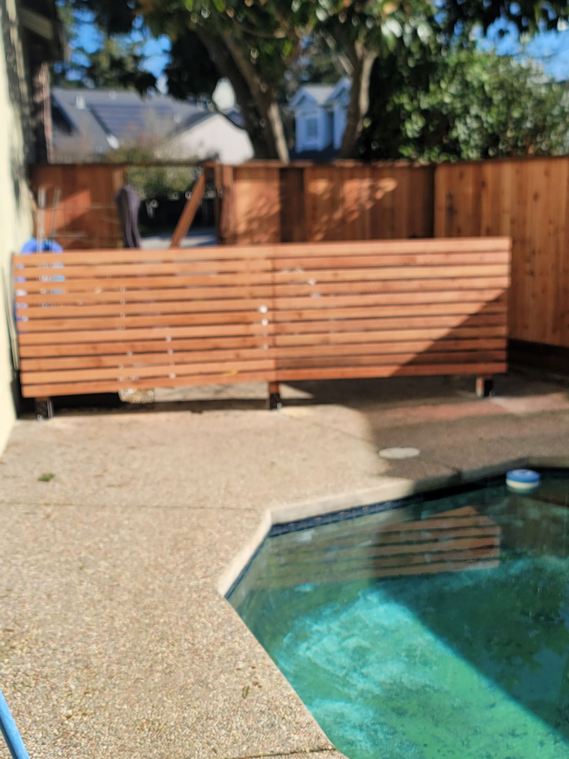 A pool with a wooden fence surrounding it