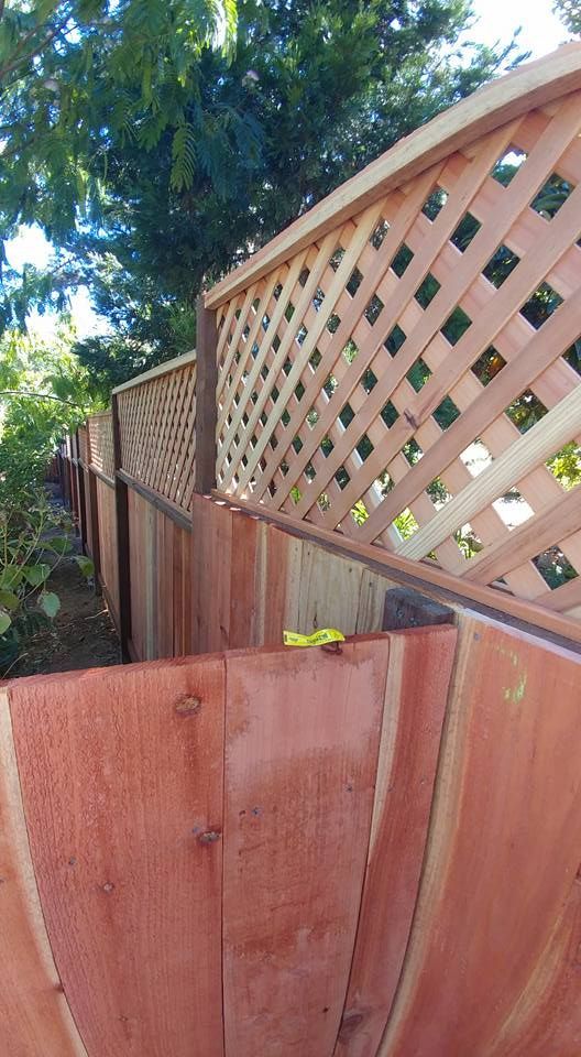 A wooden fence with a lattice in the middle of it.