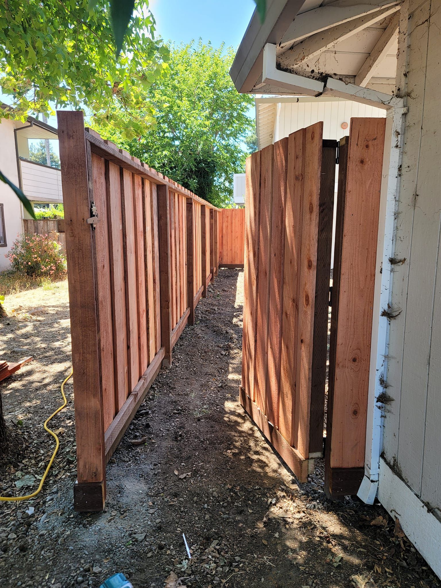 A wooden fence is being built next to a house.