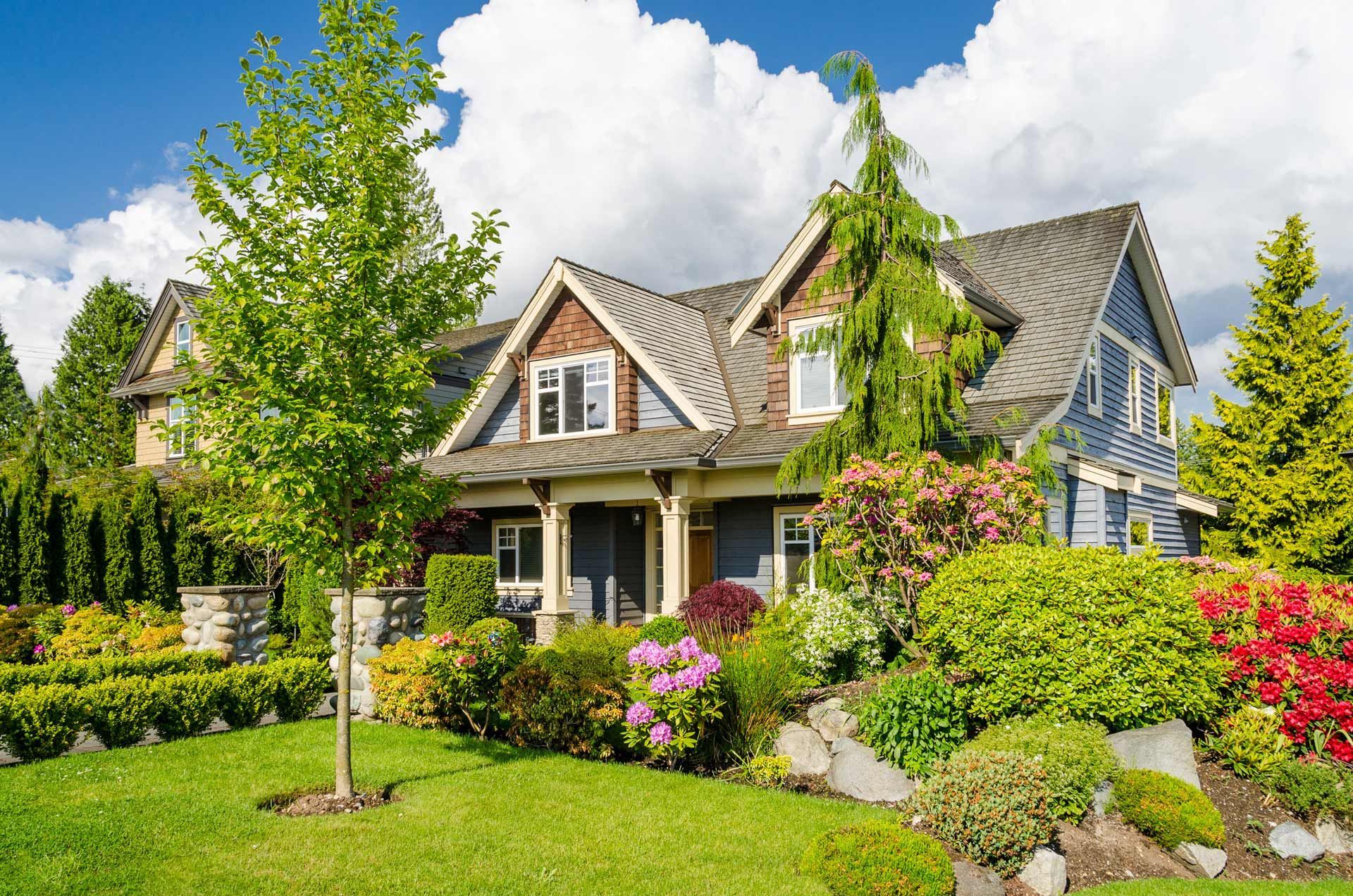 A large house with a lush green lawn and trees in front of it