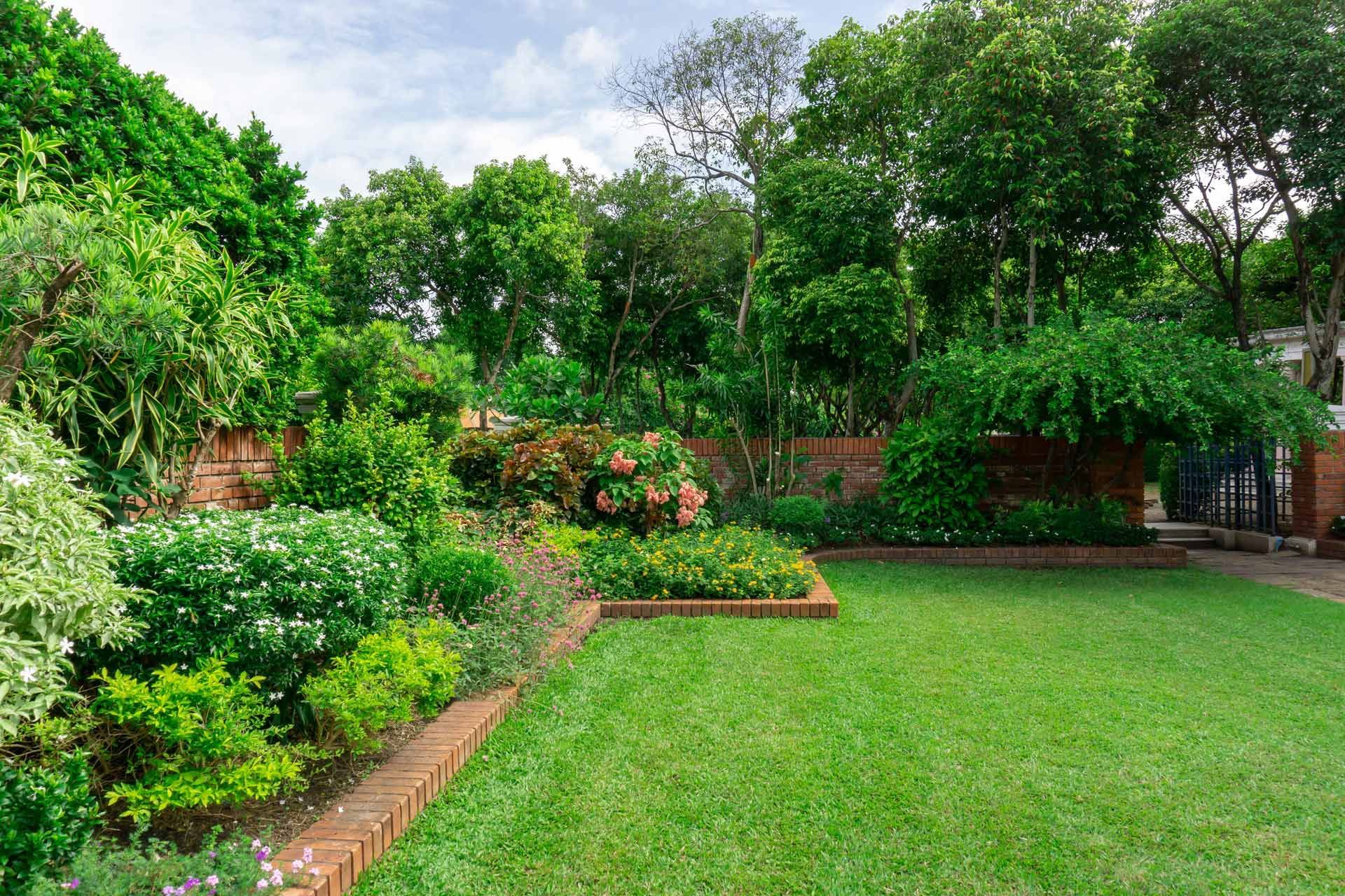 A brick wall is being built on top of a grassy hill.