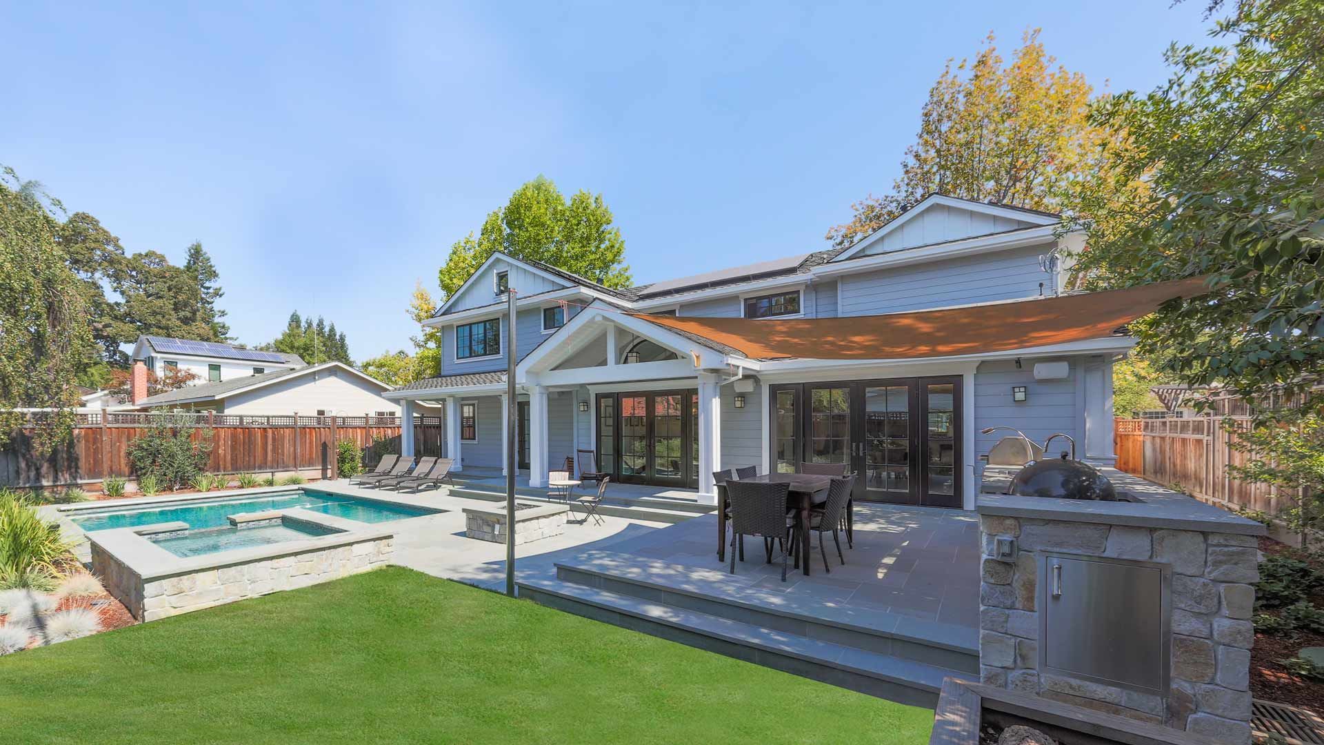 The backyard of a house with a swimming pool and a patio