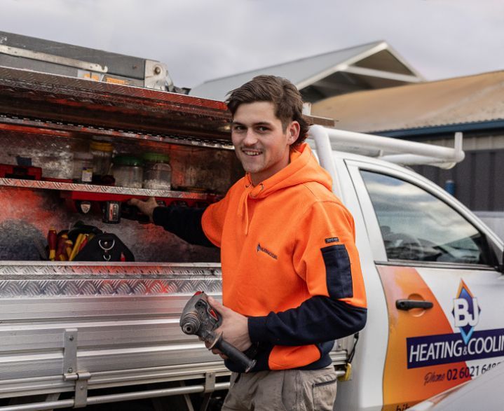 A Man Standing Next to a Heating and Cooling Truck — BJ Heating & Cooling in South Albury, NSW