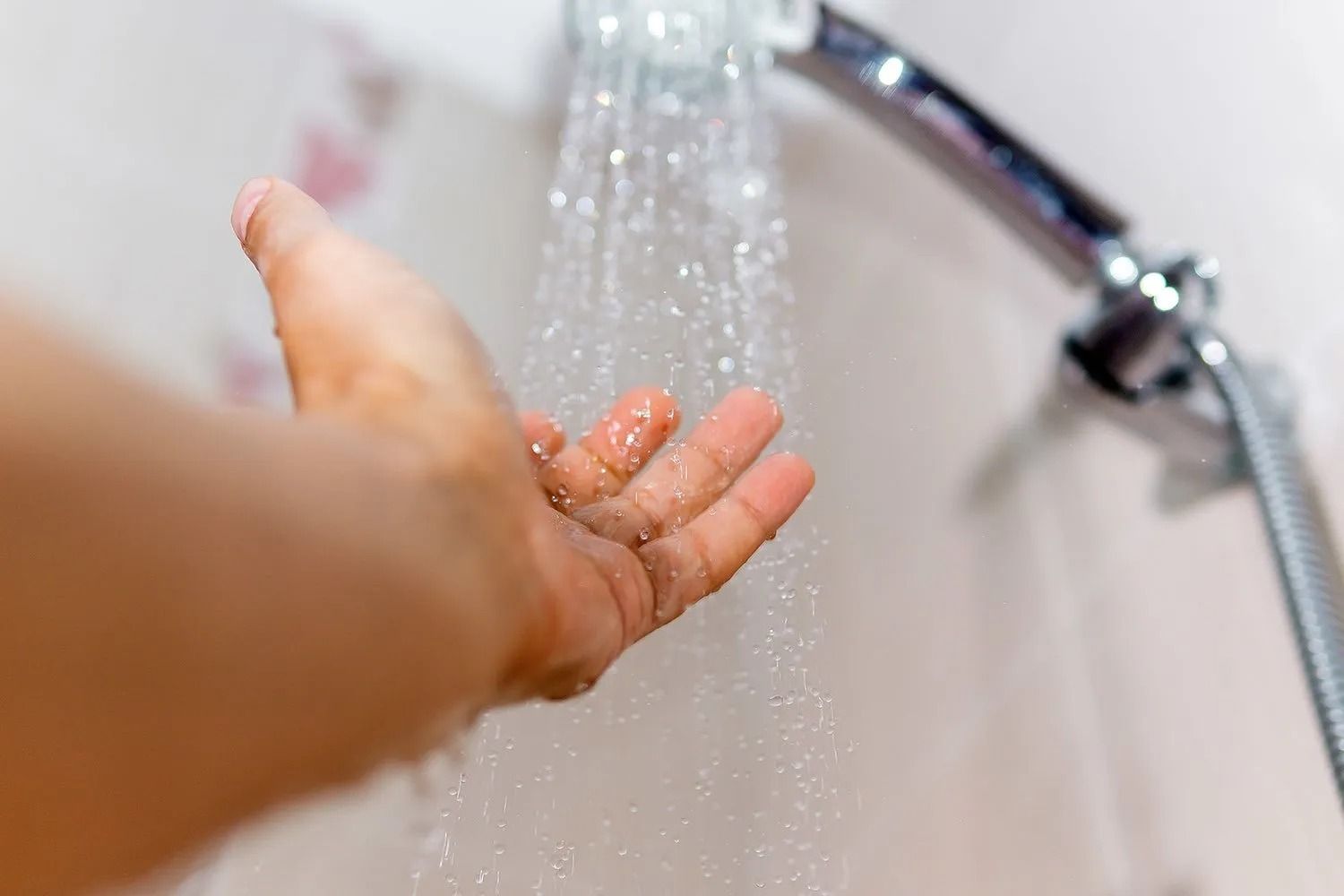 A Person is Taking a Shower With Their Hand in the Water — BJ Heating & Cooling in South Albury, NSW