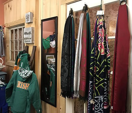 a green sweatshirt with the word irish on it is hanging on a wall next to a mirror .