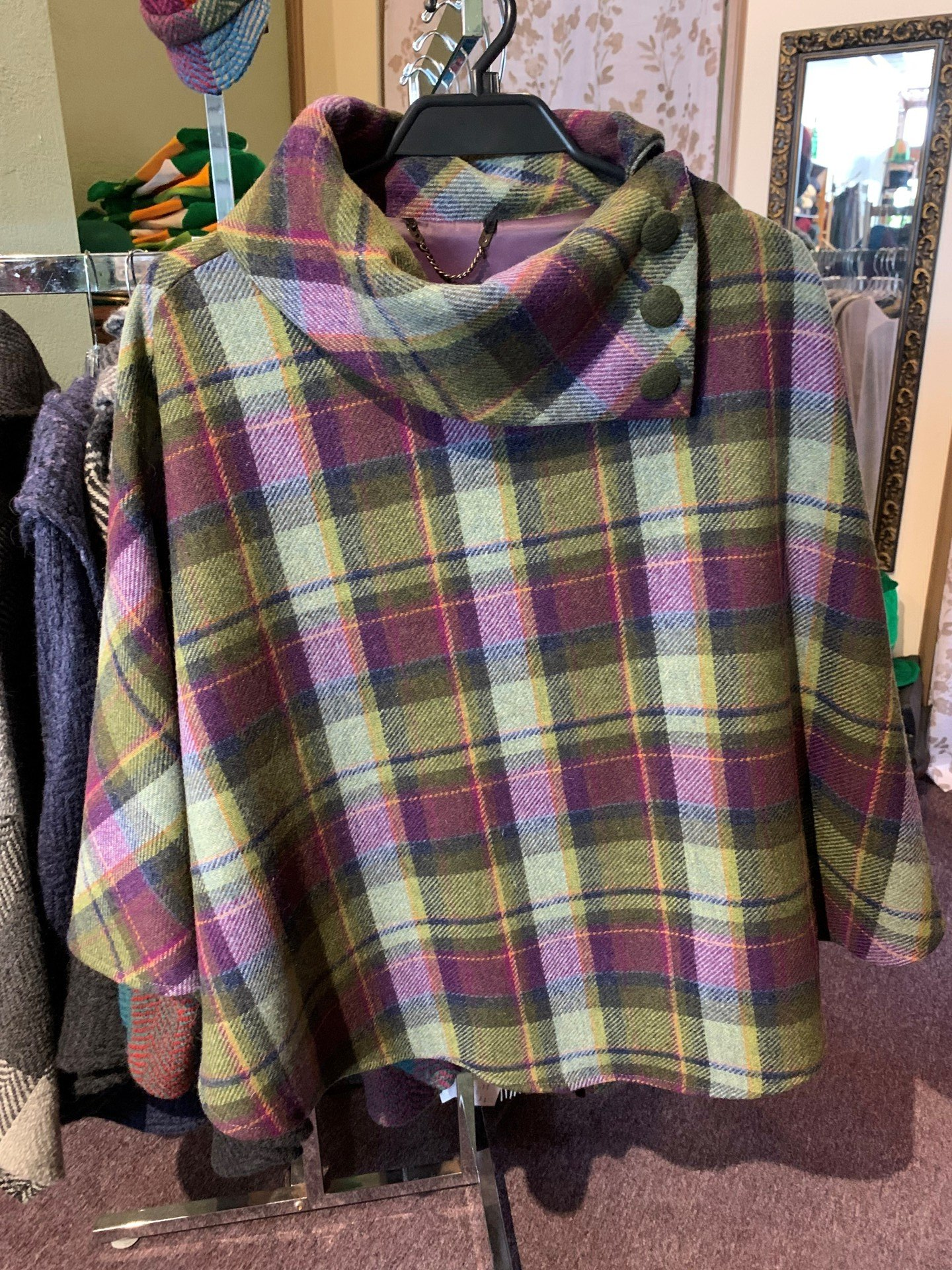 a plaid poncho is hanging on a rack in a store .