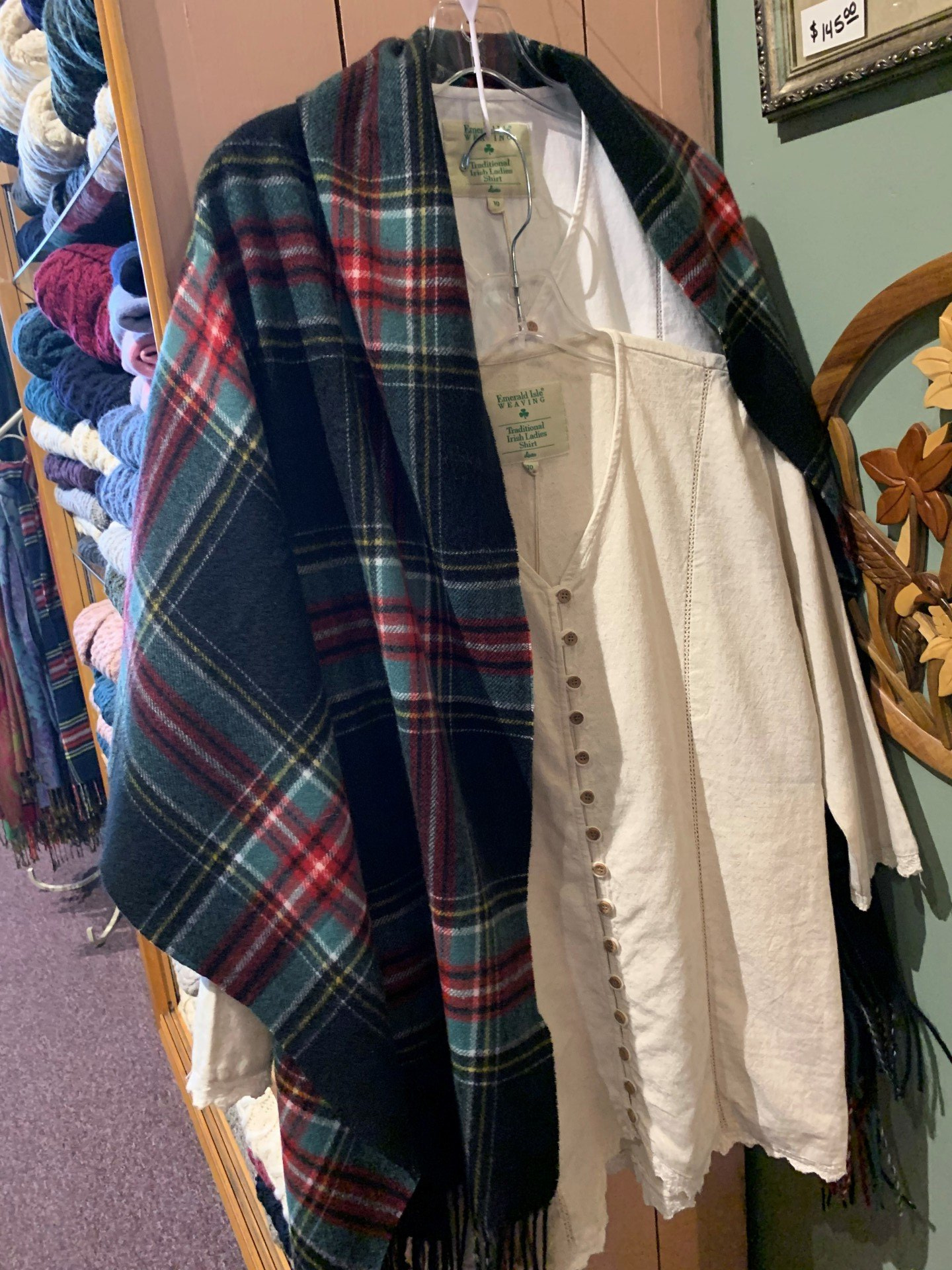 a plaid scarf is hanging on a hanger in a store .