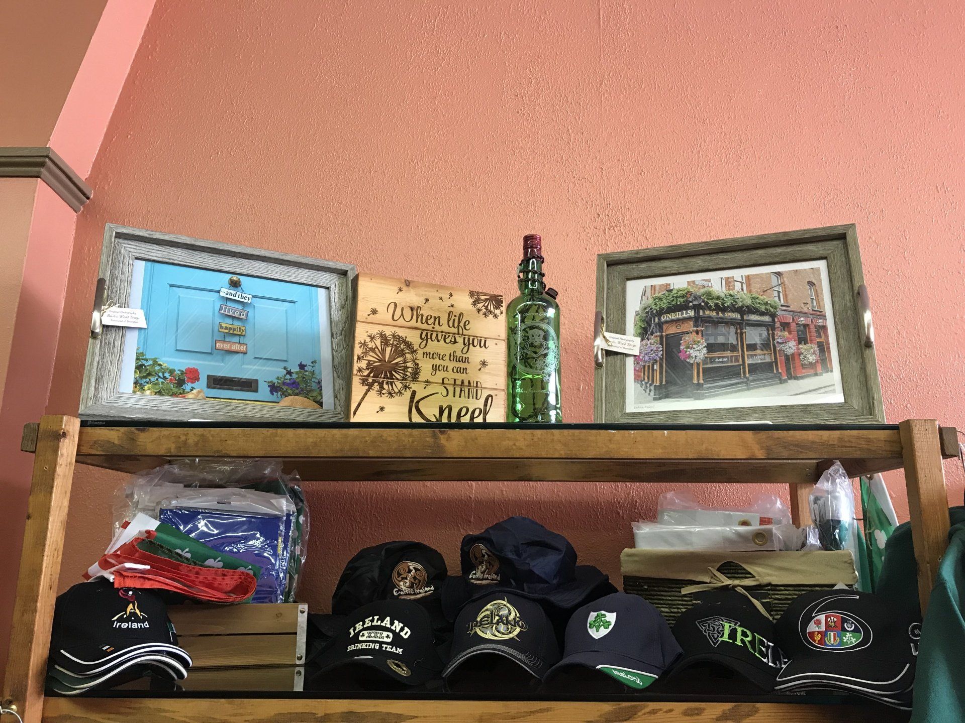 a wooden shelf filled with hats , paintings , and other items .