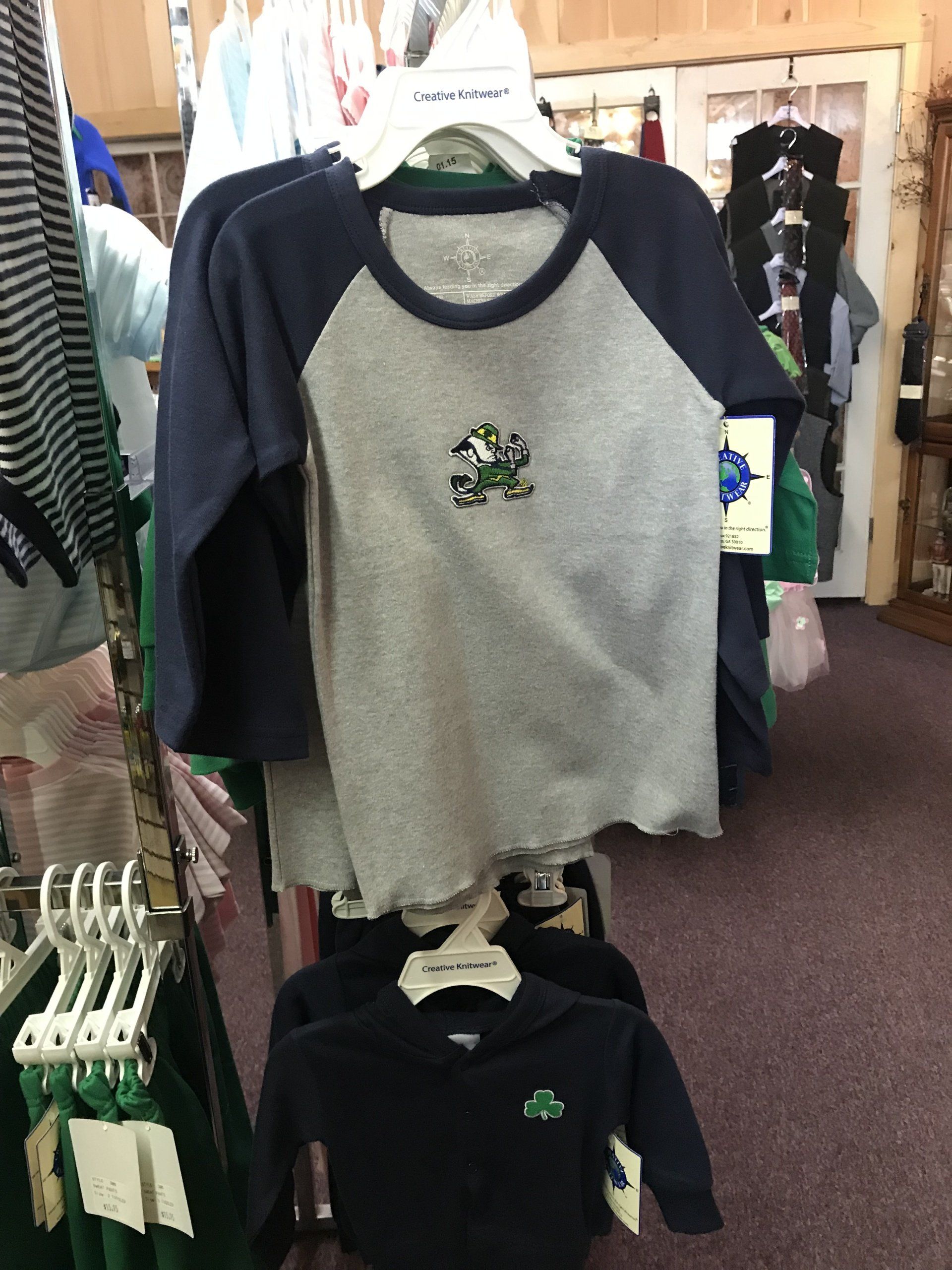 a baseball shirt with a frog on it is hanging on a rack in a store