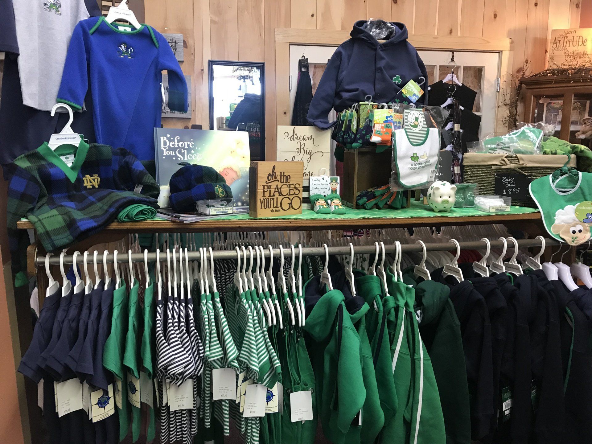 a display of green and blue clothes in a store .