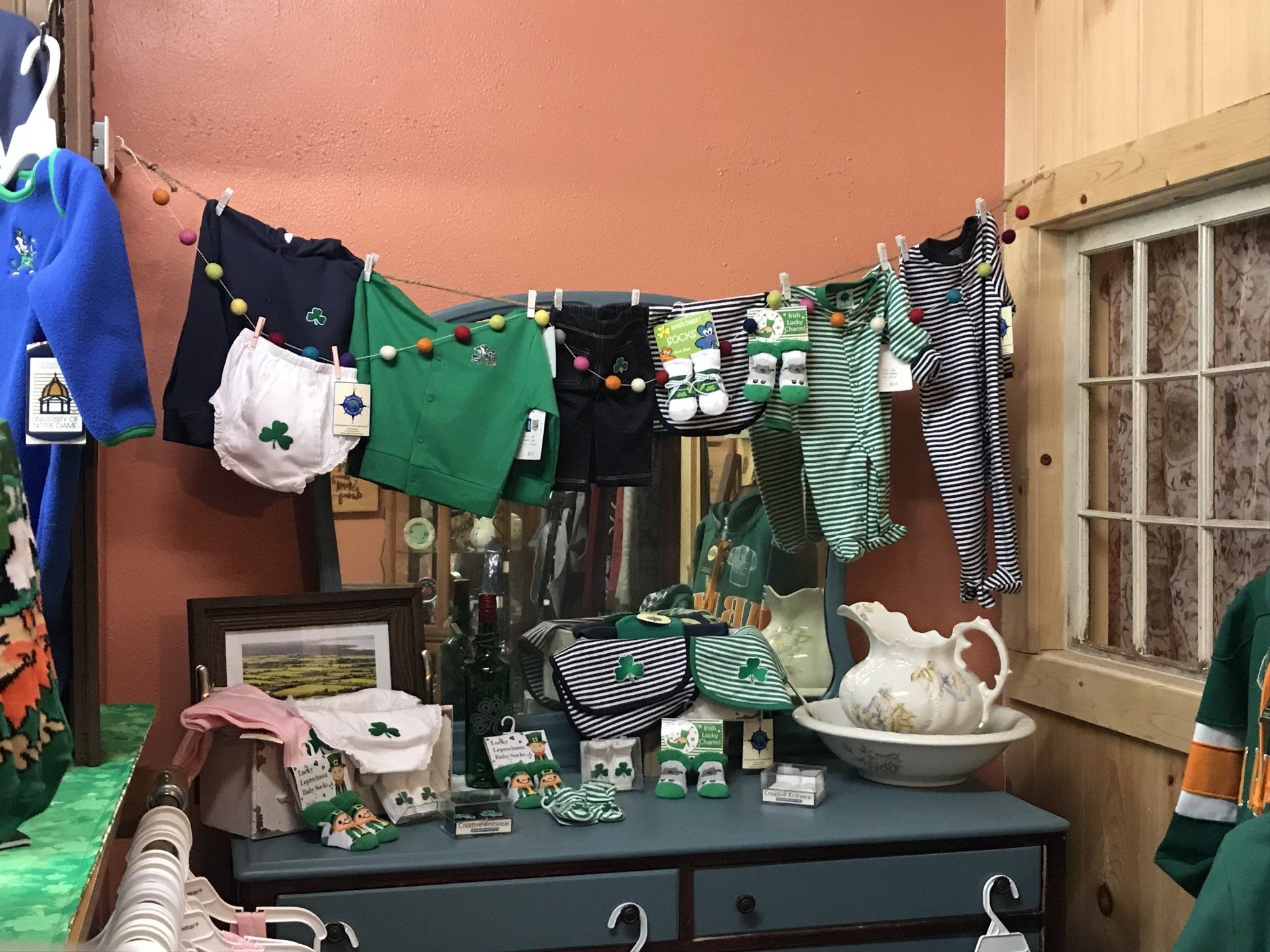 a room with a dresser and clothes hanging on a clothes line