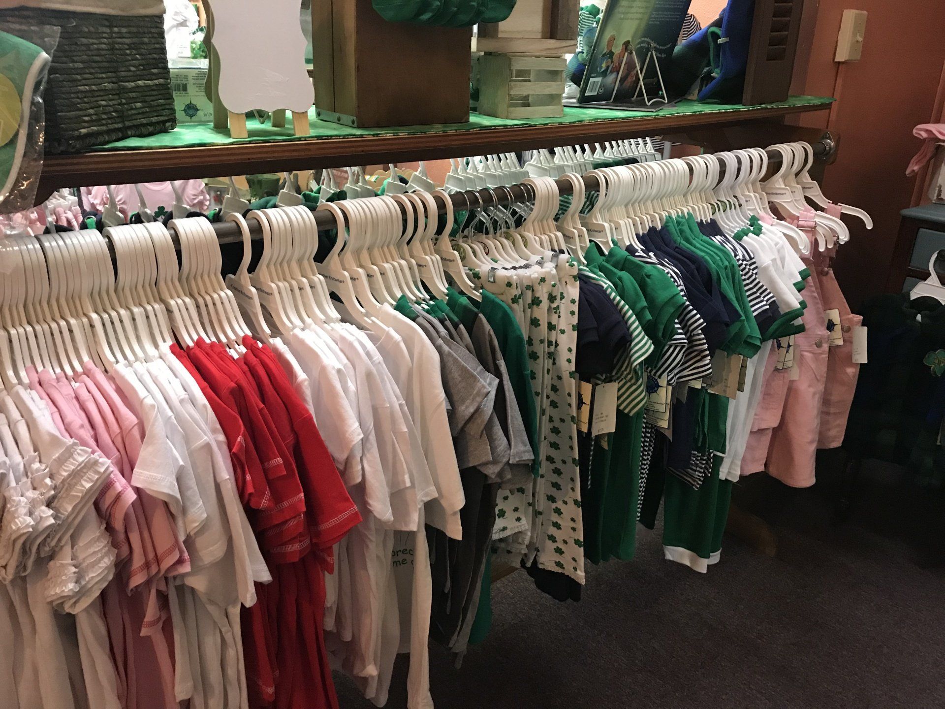 a row of baby clothes hanging on a rack in a store