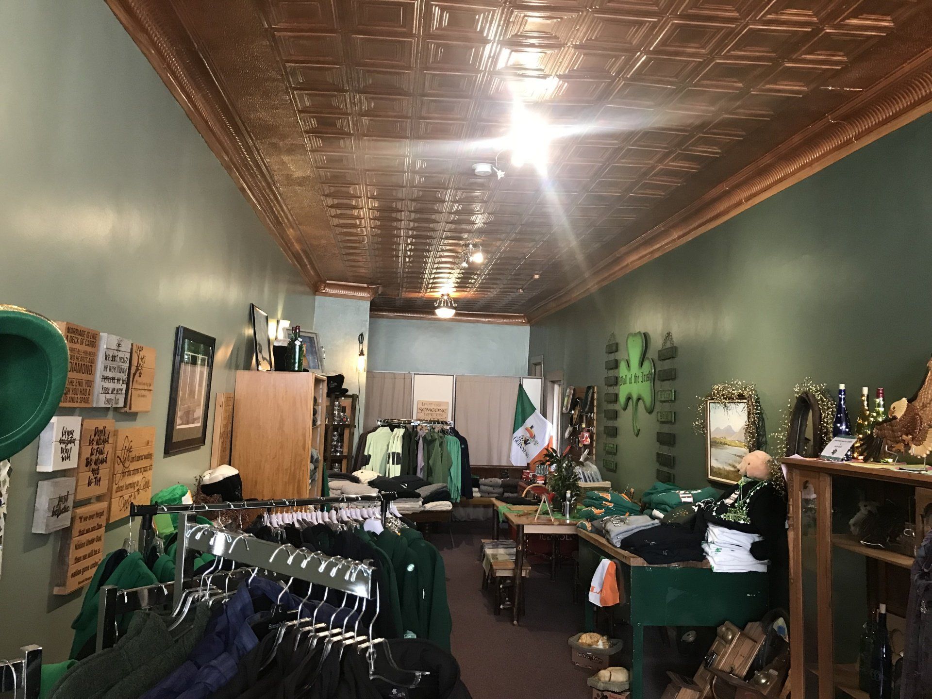 a store filled with lots of green clothes and hats .