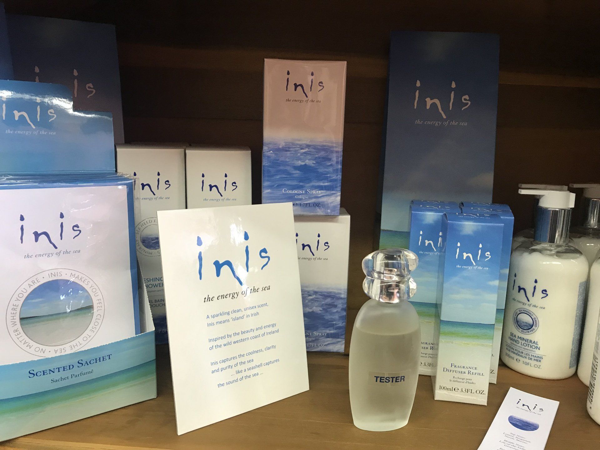 a bottle of perfume is sitting on a shelf next to a sign that says ' inis ' on it