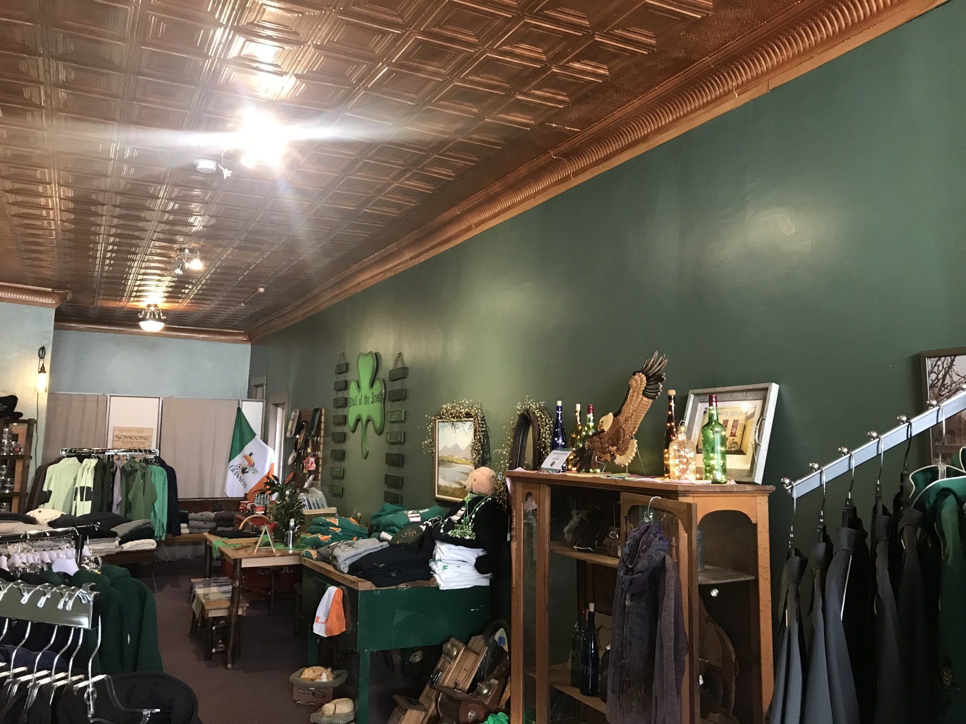 a store with green walls and a tiled ceiling