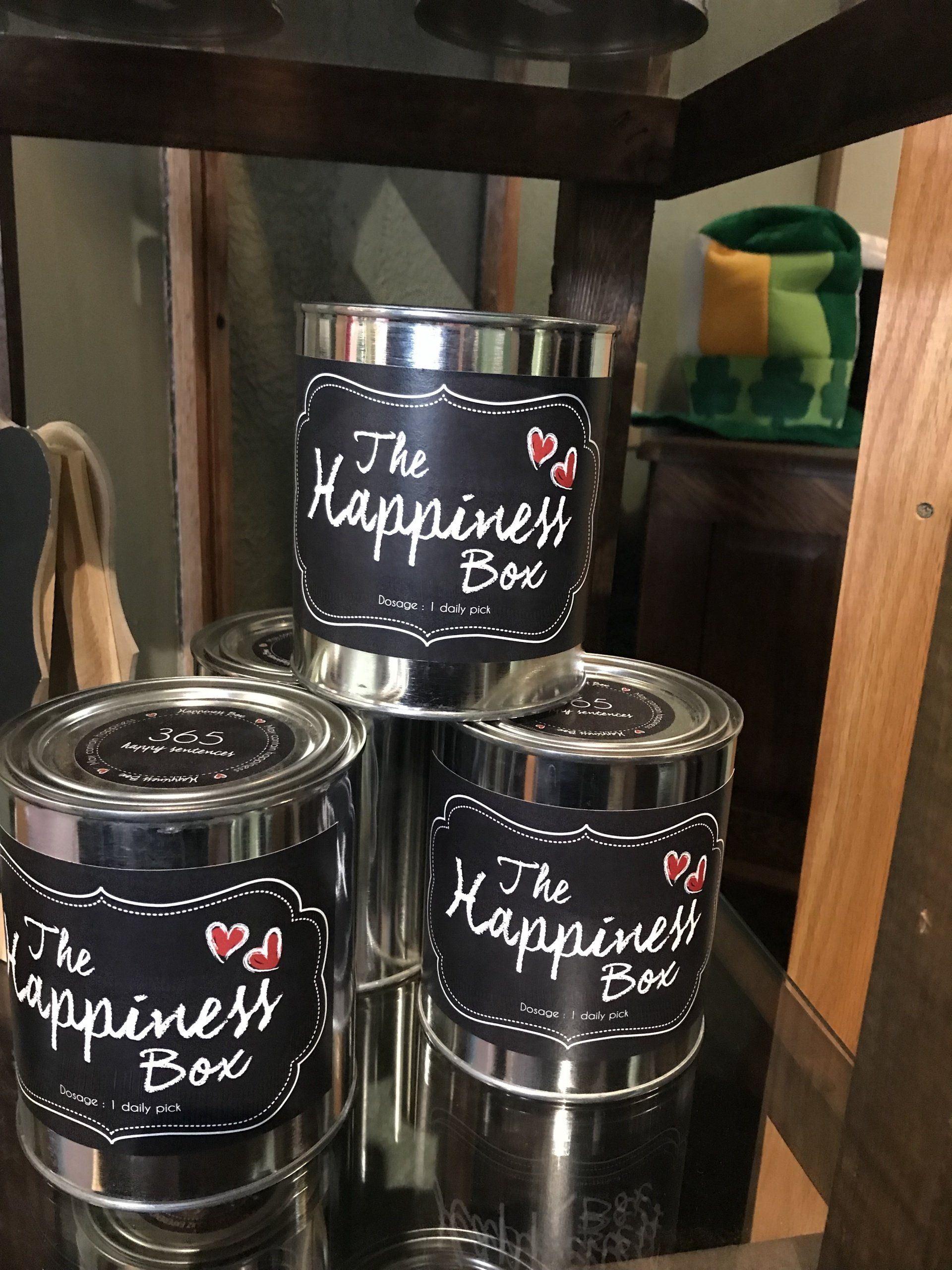 three cans of the happiness box are stacked on top of each other