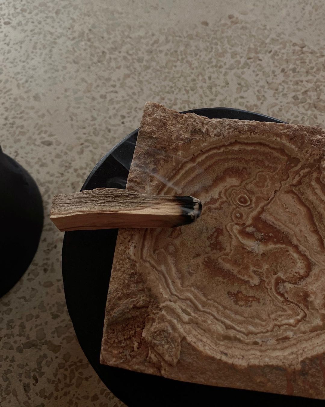 a piece of wood is sitting on top of a wooden ashtray .