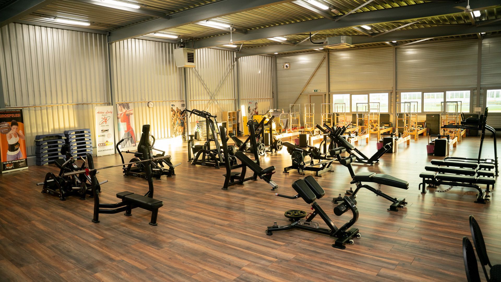 Een grote sportschool vol met fitnessapparatuur.