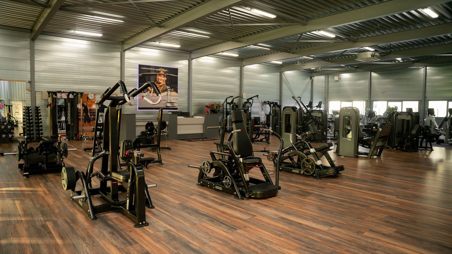 Een grote sportschool vol met fitnessapparatuur.