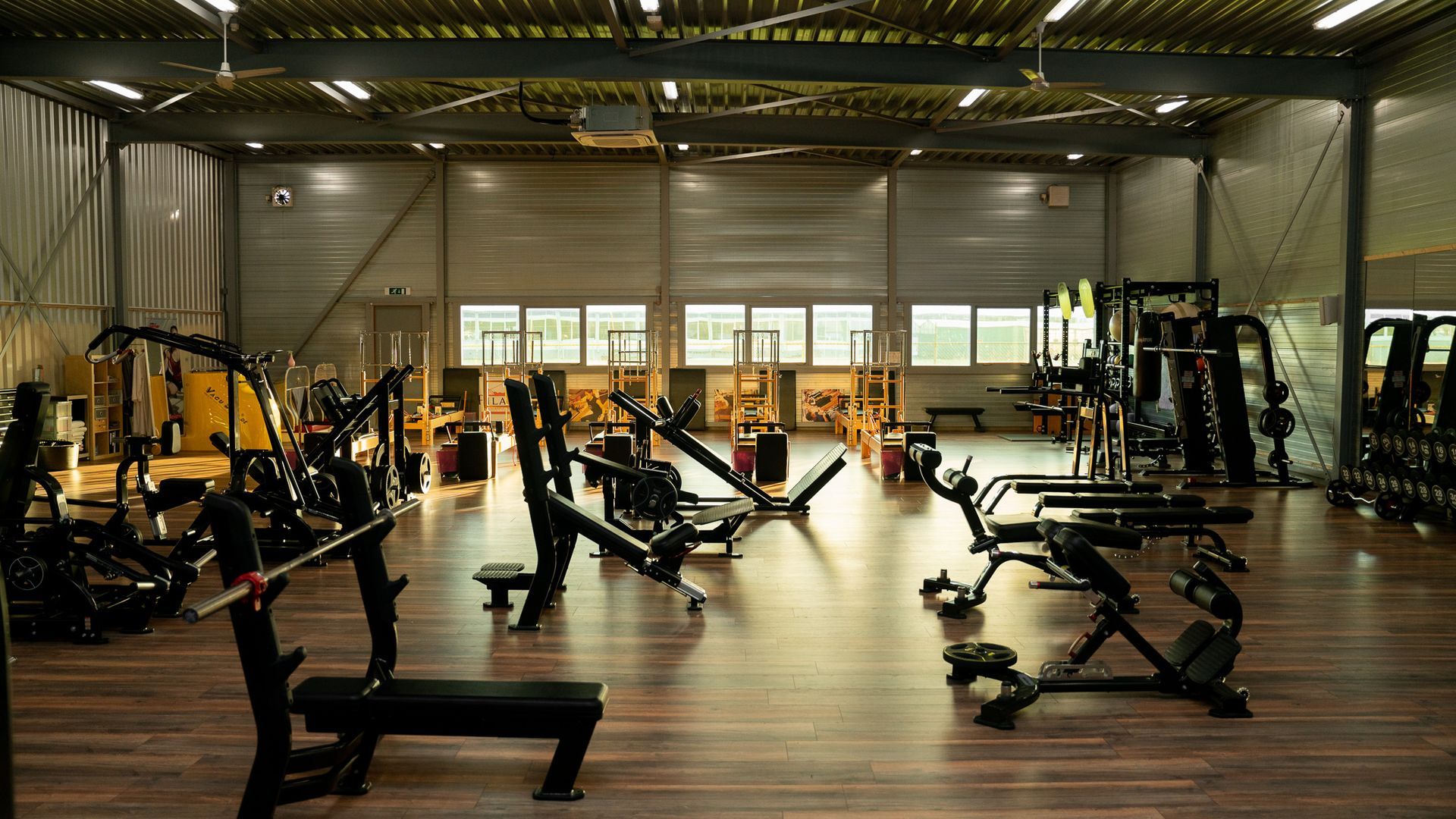 Een grote sportschool vol met fitnessapparatuur.