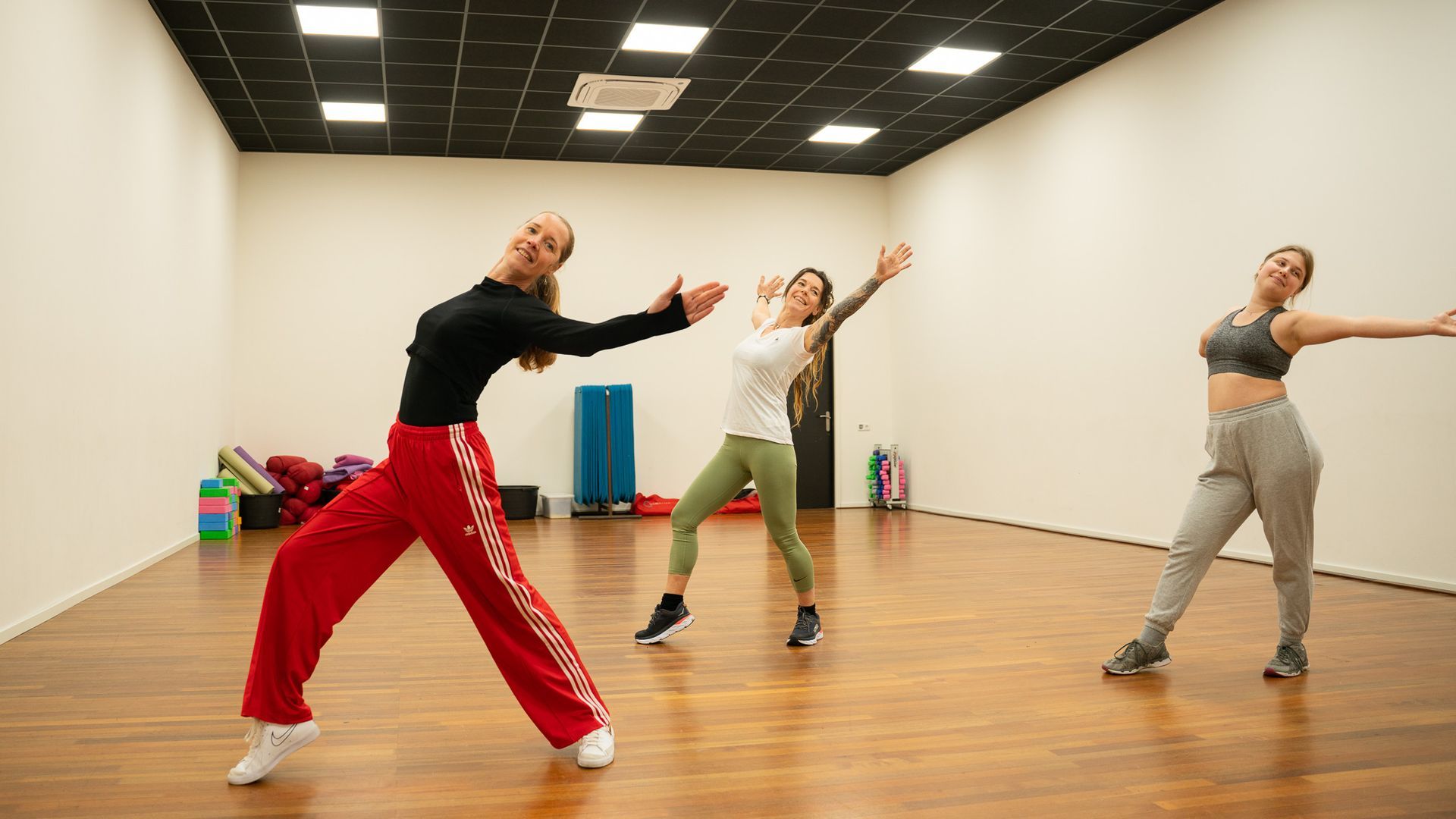 Drie vrouwen dansen in een dansstudio.