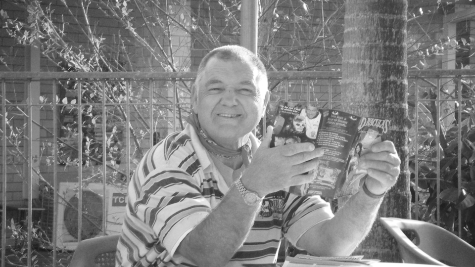 Male sitting outside reading a brochure 