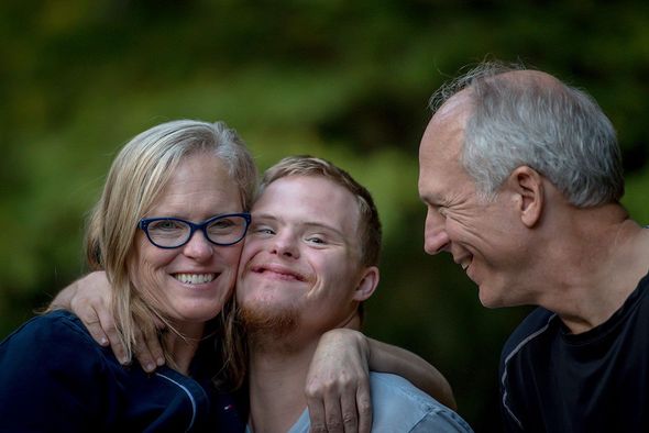 Female and Male support worker and young man smiling together outdoors