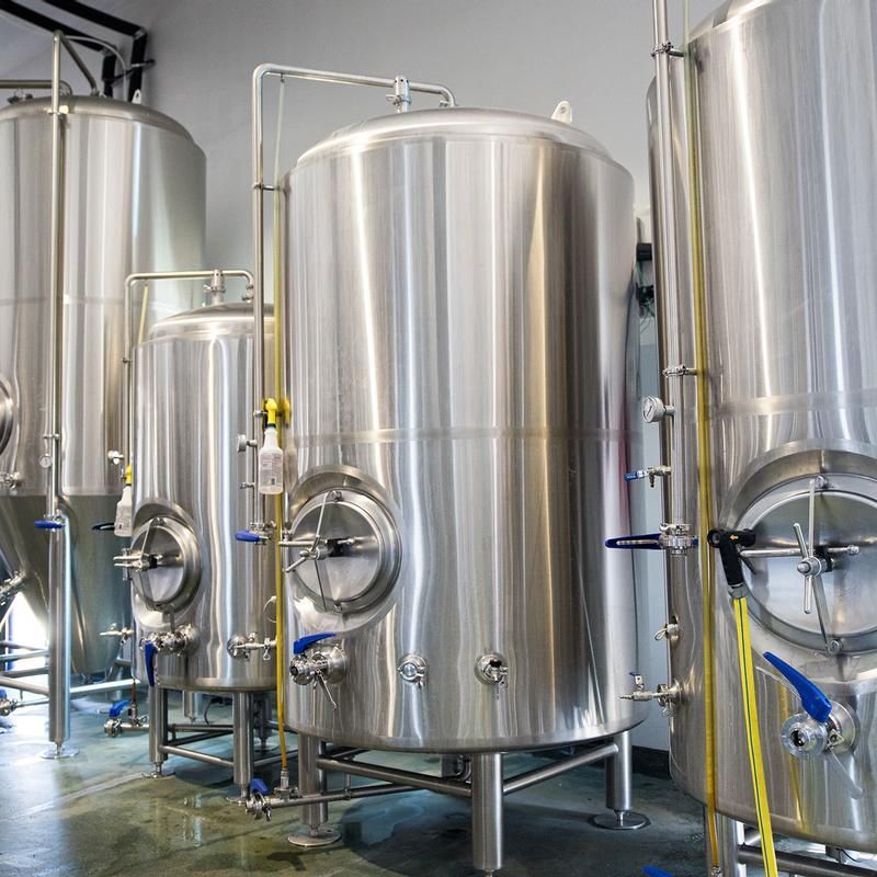 A row of stainless steel tanks in a brewery