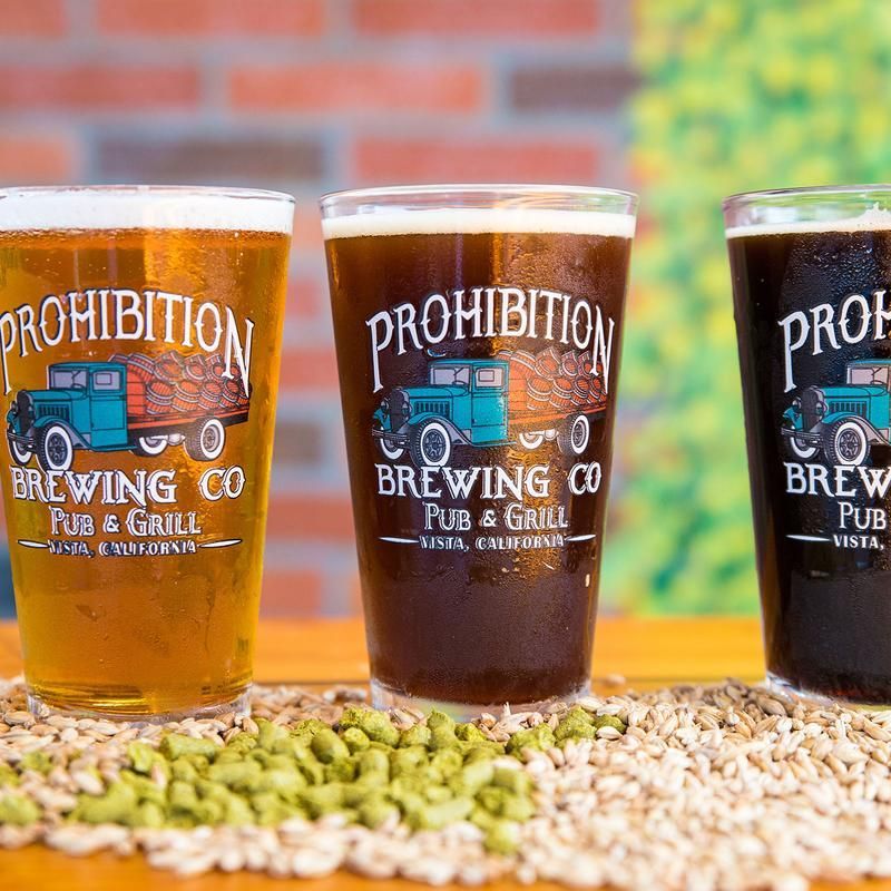 Three glasses of beer are sitting on top of a table.