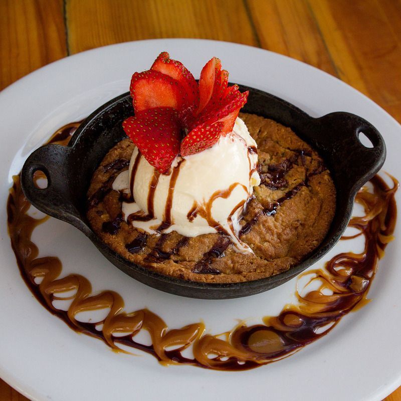 A cookie with ice cream and strawberries on top