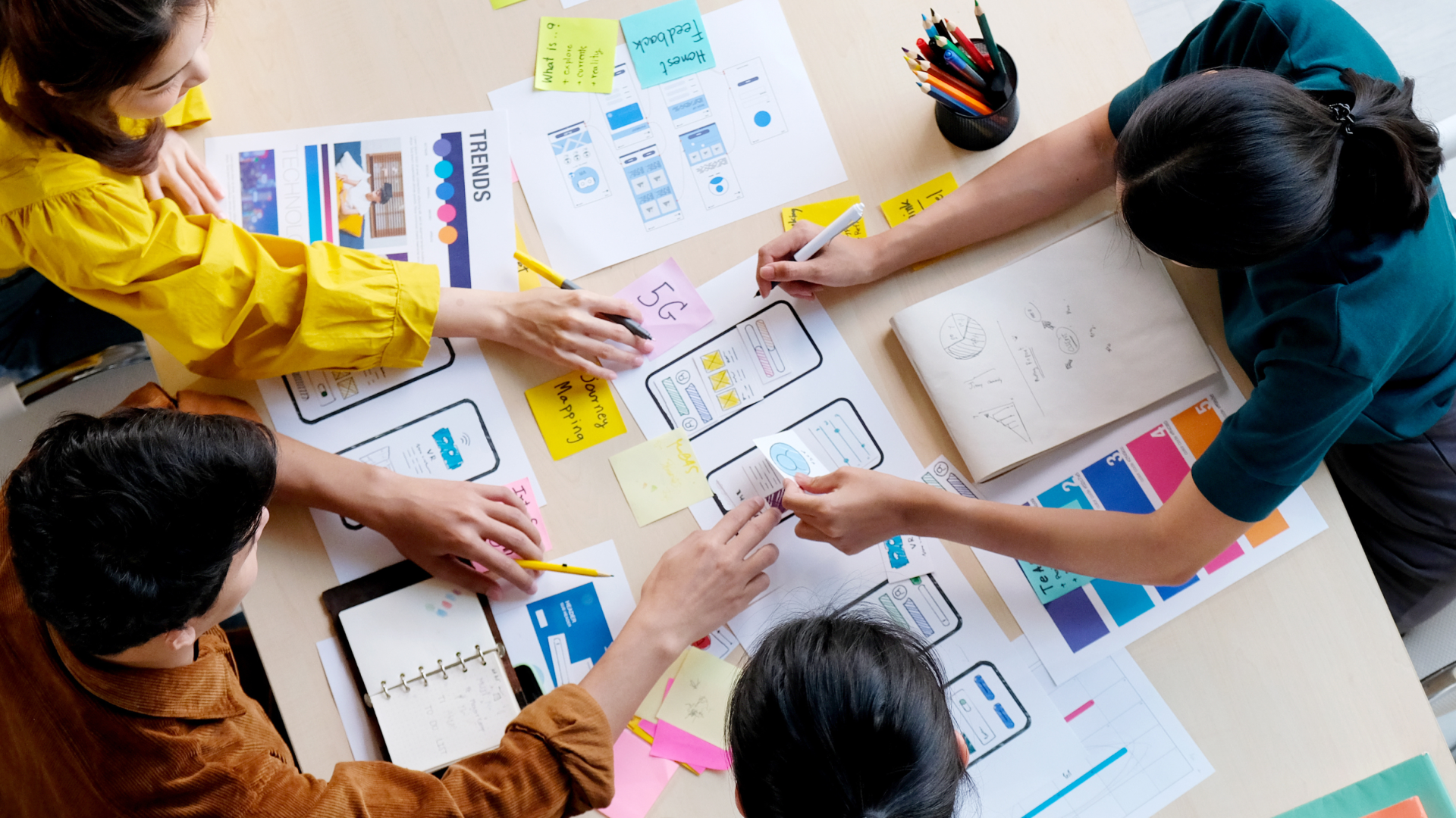 A group of people are sitting around a table working on a project.