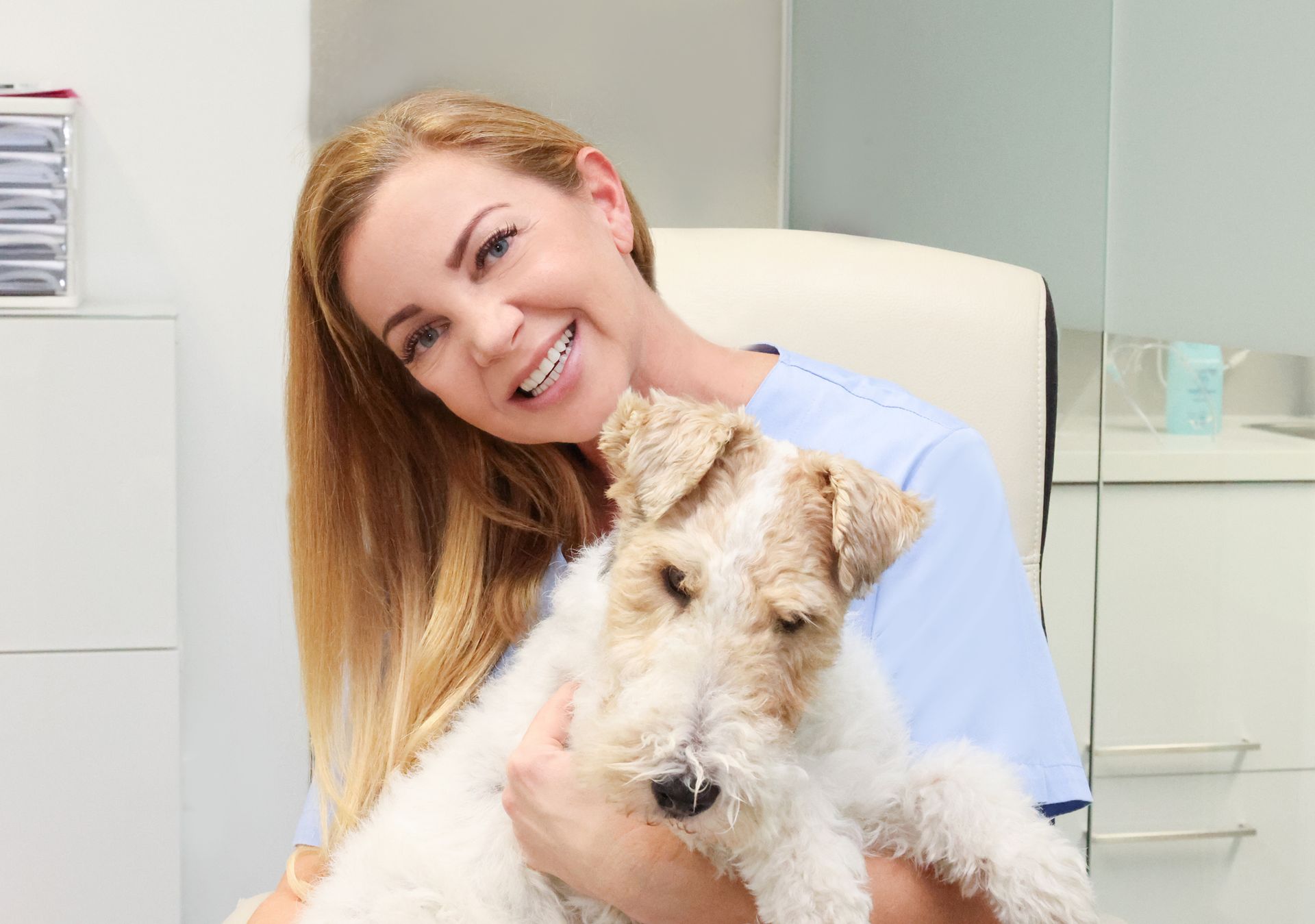 Eine Frau hält einen kleinen Hund in ihren Armen.