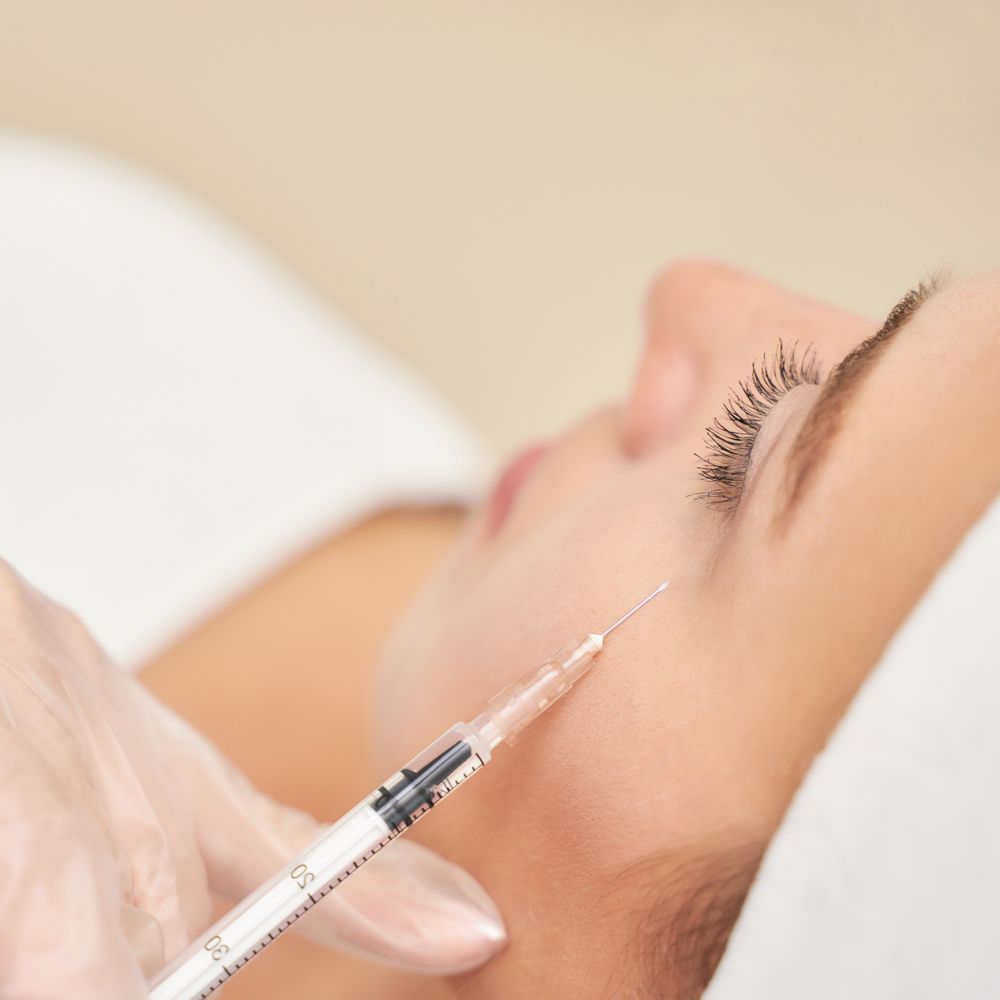 A woman is getting a botox injection in her face.