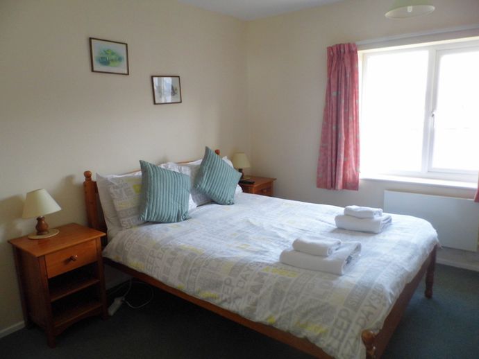 Double bed in main bedroom, Wherry Cottage with large window view to river.