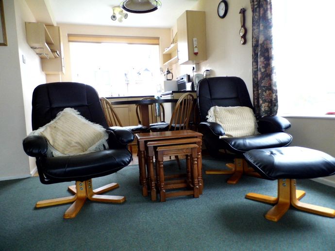 2 leather arm chairs, footstool, and nest of tables in Wherry Cottage.