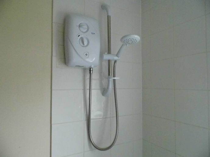 Electric shower over bath in Wherry Cottage