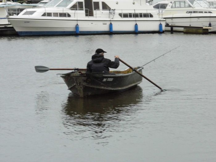 fisherman in fishing rowing boat on River Bure.
