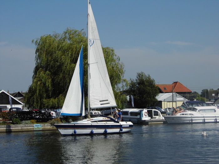 A sailing yacht passing Wherry cottage on River Bure