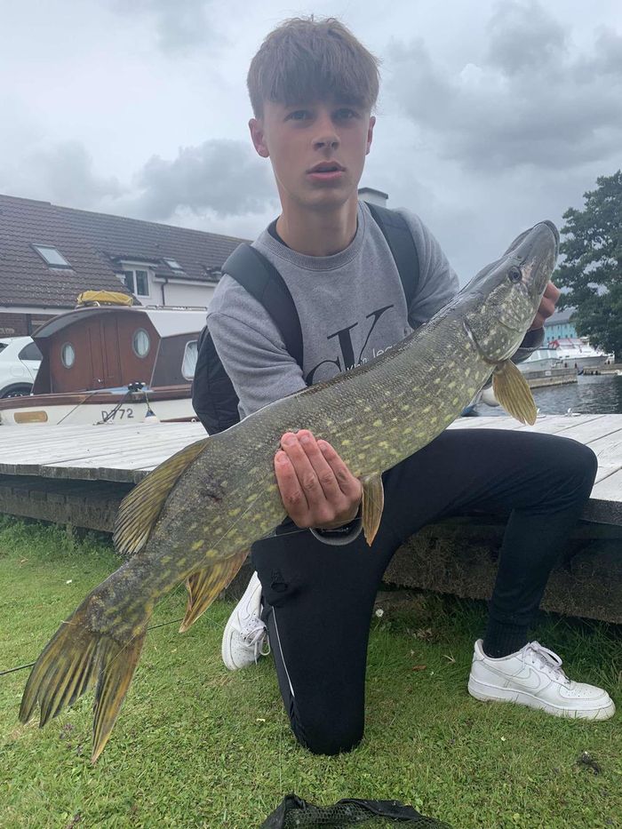 Teenager holding a huge pike just caught on River Bure, Wroxham