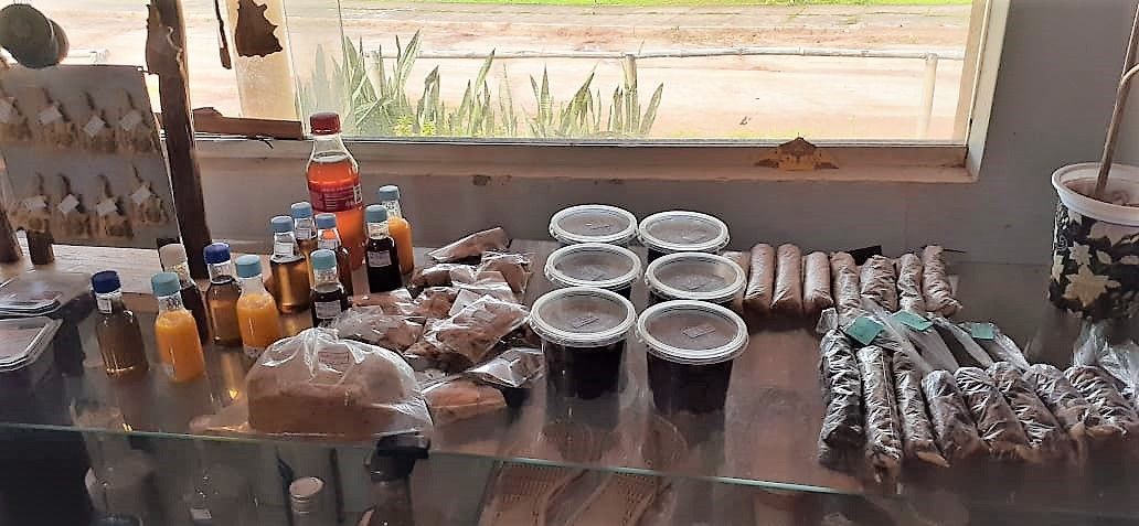 Uma mesa cheia de comida e bebida em frente a uma janela.