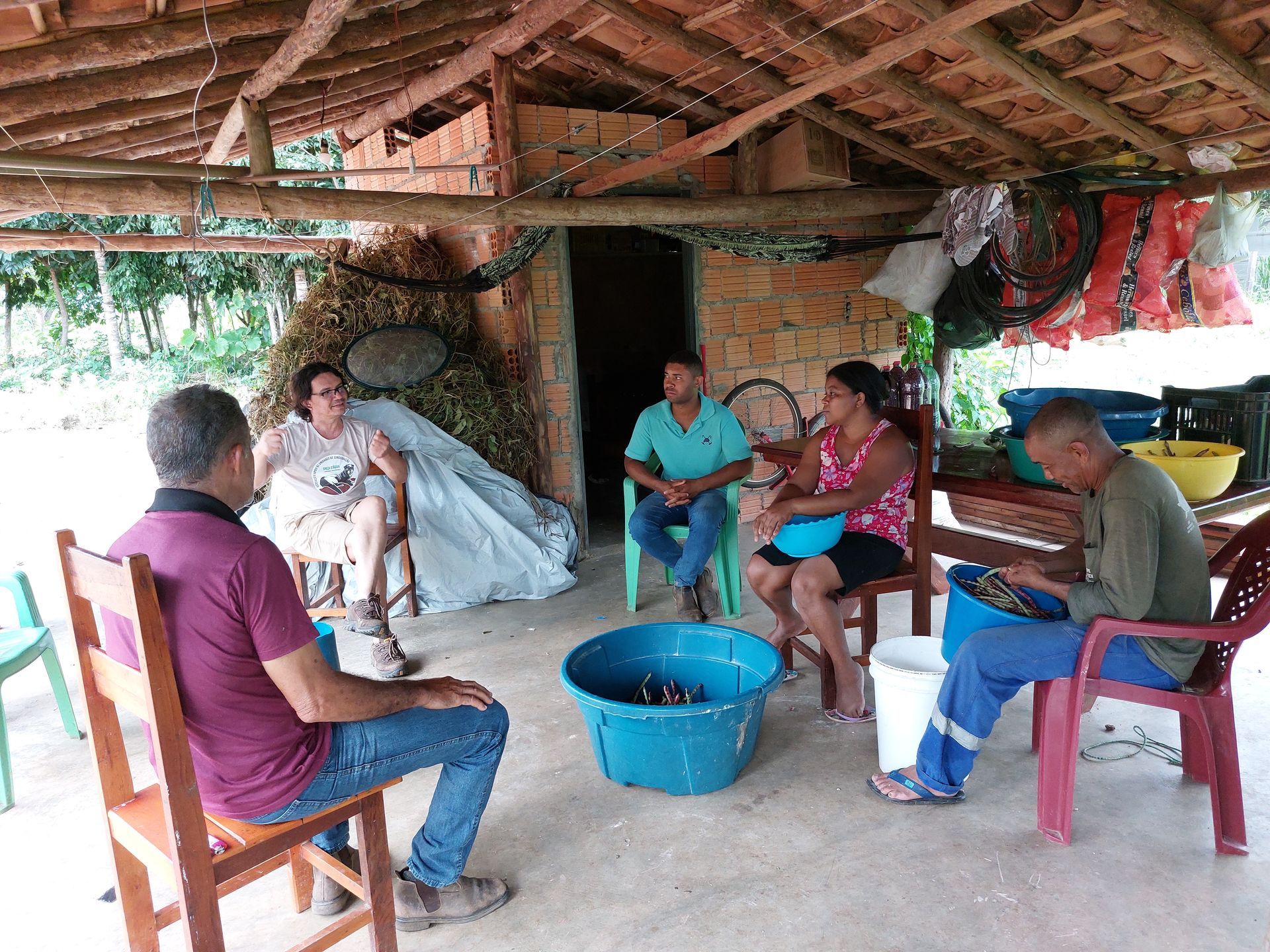 Um grupo de pessoas está sentado ao redor de uma mesa em uma cabana.