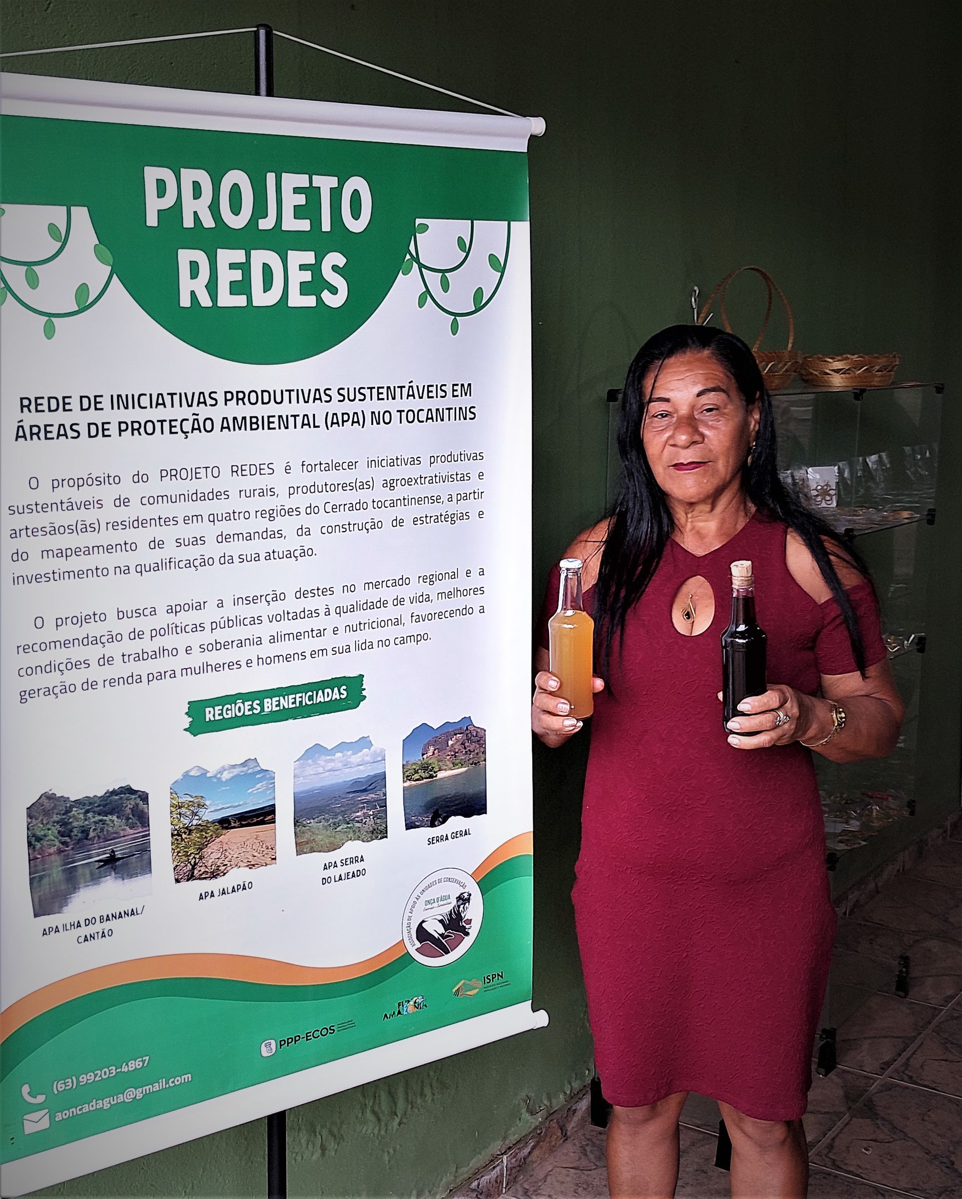 Uma mulher está parada em frente a uma placa que diz projeto redes