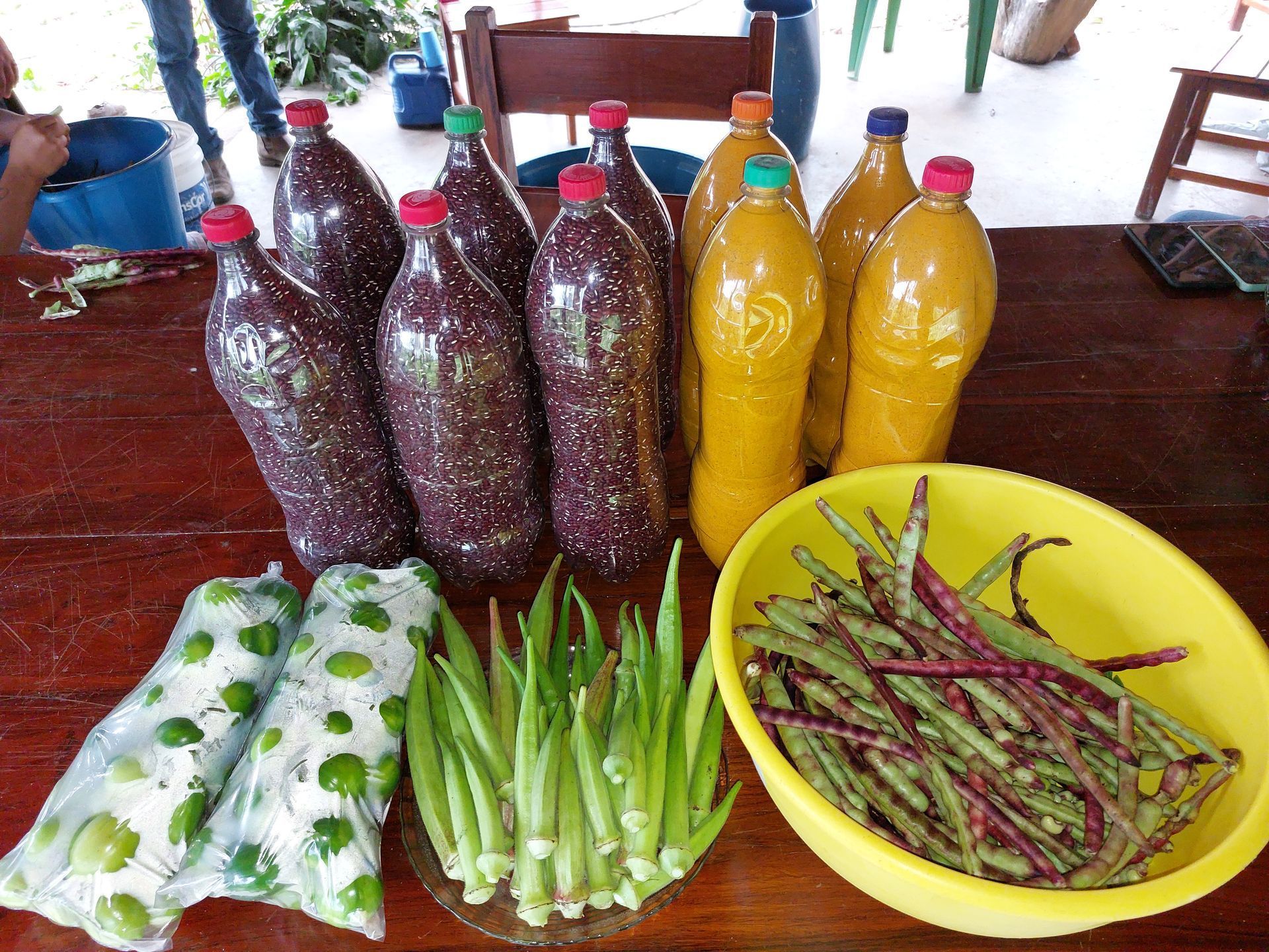 Uma mesa com garrafas e uma tigela de feijão verde
