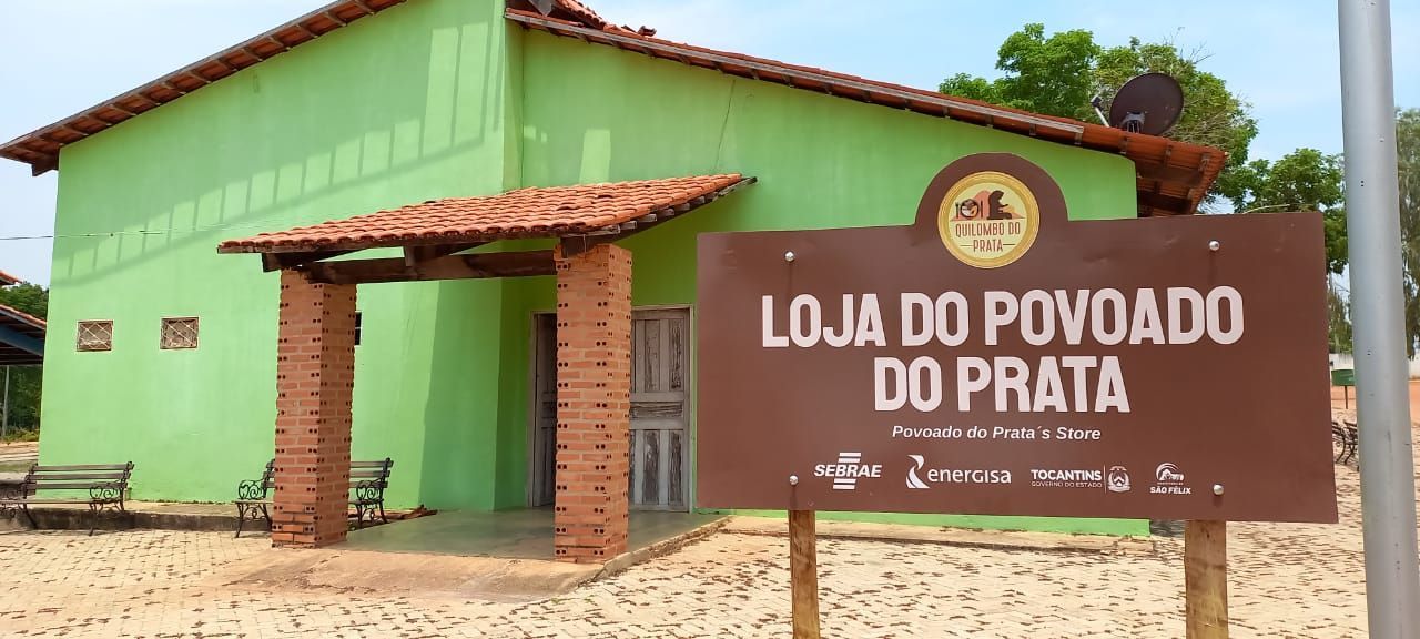 A green building with a sign that says loja do povoado do prata